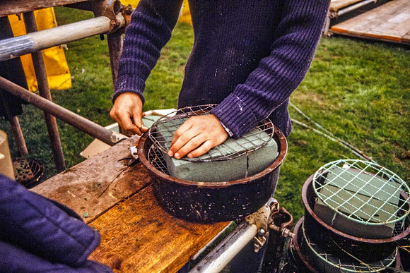 Oasis and staging wires being fitted into washing up bowl.
